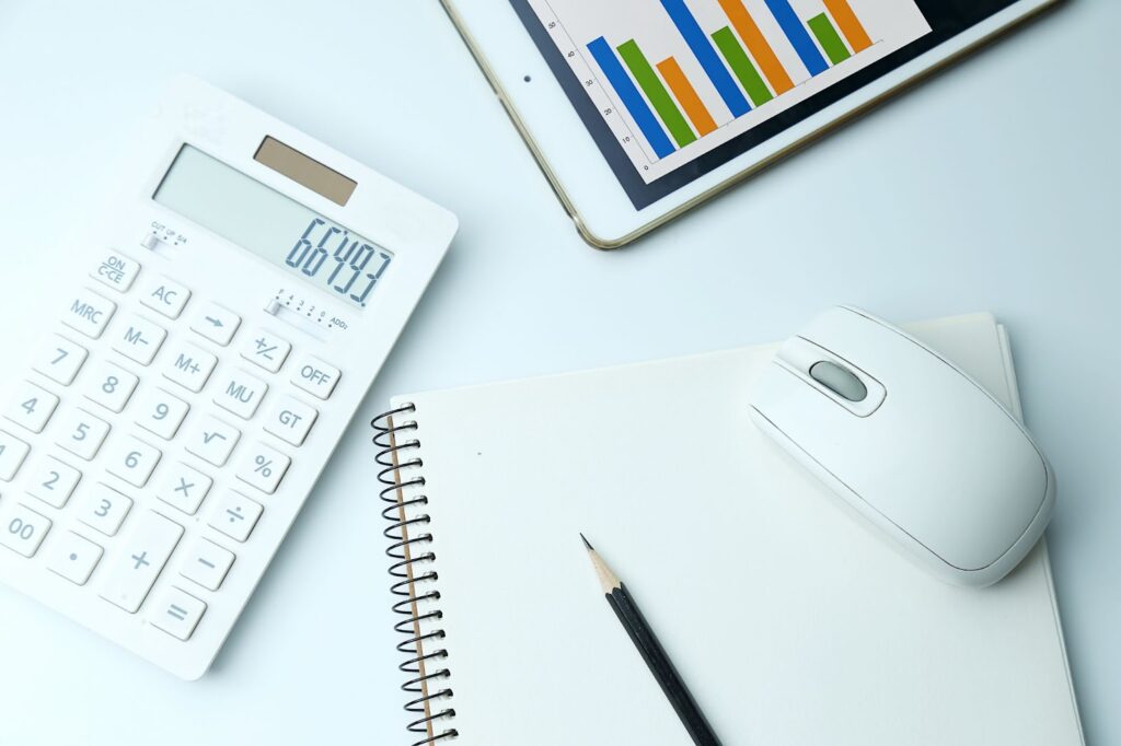 Top view of calculator, notebook and financial statistic